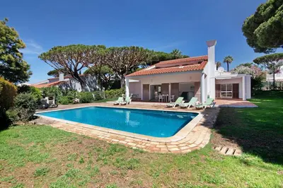 a swimming pool in front of a house at Villa Lynn - Quadradinhos in Almancil