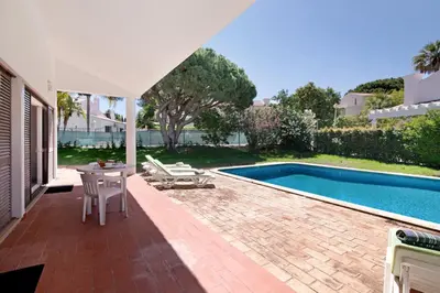 a patio with a table and a swimming pool at Villa Lynn - Quadradinhos in Almancil