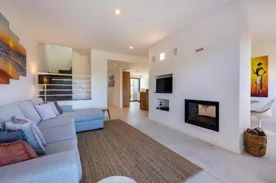 a living room with a blue couch and a fireplace at Casa Esmarand in Albufeira
