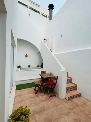 a room with a table and a stairway with a table and chair at Casa Longa Faro - Traditional Portuguese House with modern comforts in Faro