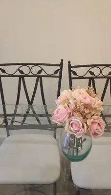 a vase filled with pink roses sitting next to a chair at Grand studio 29 in Faro