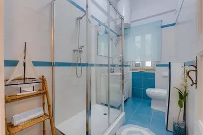 a bathroom with a glass shower and a toilet at Casa LOTUS - Requinte e bom gosto para 6 pessoas no coração de Faro in Faro