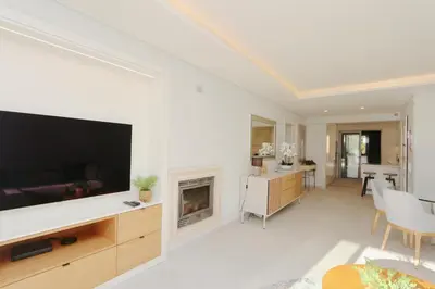 a living room with a large television and a fireplace at Birdie Bliss Apartment - CleverDetails - Sleeps 4 Adults and 1 Child in Vilamoura