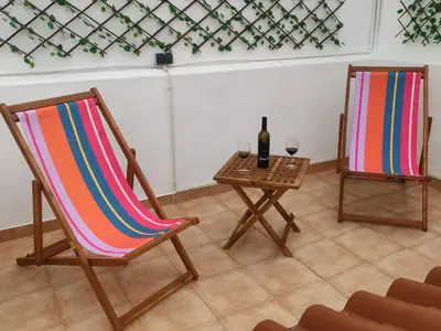 two chairs and a table with a bottle of wine at Casa da Madalena in Faro