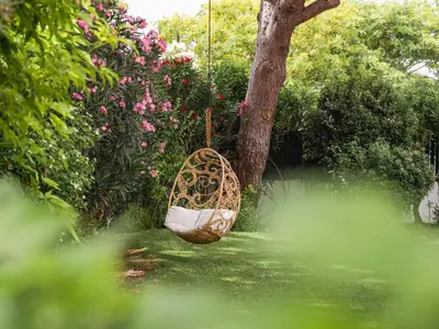 a swing hanging from a tree in a garden at Beach villa Casa de Amanhã 450 mts to the beach with beautiful garden and heated saltwater pool in Albufeira