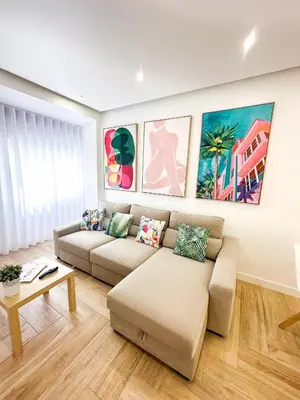 a living room with a couch and paintings on the wall at Apartments Home Sweet Home in Faro