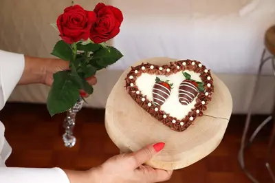 a person holding a heart shaped cake and a rose at Apartments Home Sweet Home in Faro