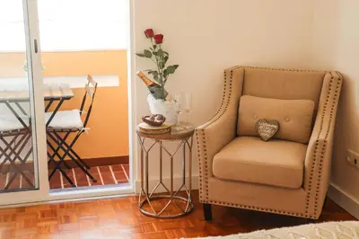 a room with a chair and a table with a vase at Apartments Home Sweet Home in Faro