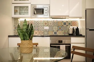 a kitchen with a glass table with a plant at Apartments Home Sweet Home in Faro