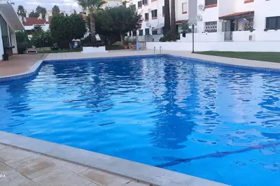 a large blue swimming pool in a building at Cadete house in Albufeira