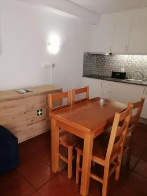 a kitchen with a wooden table and four chairs at Cadete house in Albufeira