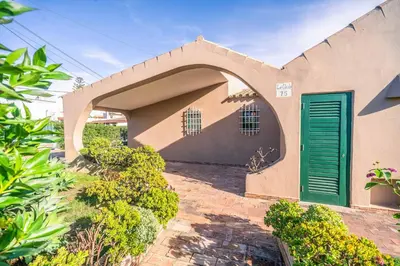 a house with a green door on the side of it at Villa Silveira in Vilamoura
