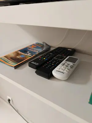 two remote controls sitting on top of a desk at Apartamento Páteo - piscina, churrasqueira e vista jardim in Albufeira
