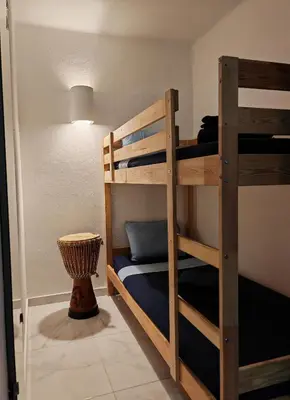 a bunk bed room with two bunk beds and a lamp at Apartamento Páteo - piscina, churrasqueira e vista jardim in Albufeira