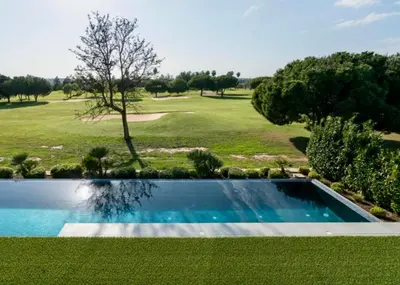 a swimming pool in front of a golf course at Villa Algarve Paradise in Vilamoura