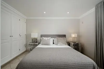 a white bedroom with a large bed and two lamps at Villa Grace in Almancil