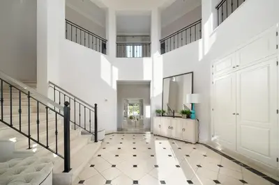a hallway with white walls and a staircase with a white door at Villa Grace in Almancil