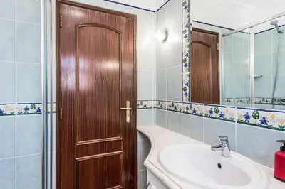 a bathroom with a sink and a wooden door at Villa Katharina in Albufeira
