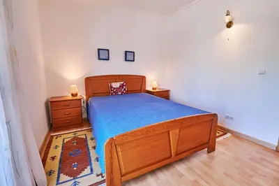 a bedroom with a wooden bed and two night stands at Casa Felix mit Pool in Albufeira