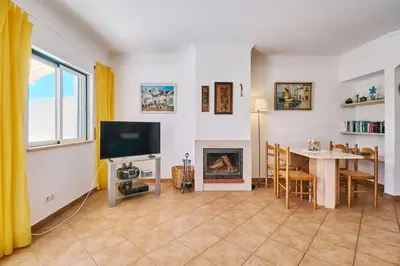 a living room with a table and a fireplace at Casa Felix mit Pool in Albufeira