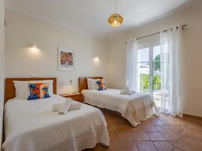 a bedroom with two beds and a desk and a window at Pine Haven in Faro