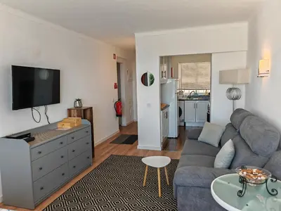 a living room with a couch and a tv at Apartamento Oura com piscina e vista mar in Albufeira