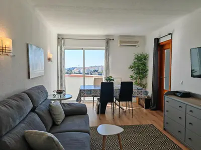 a living room with a couch and a table at Apartamento Oura com piscina e vista mar in Albufeira