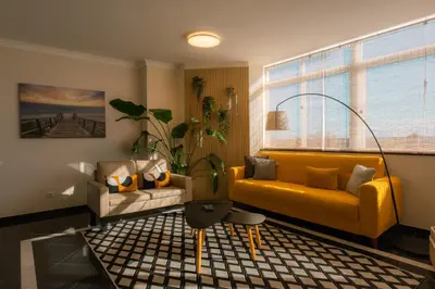 a living room with a yellow couch and a table at Sweet Formosa View in Faro
