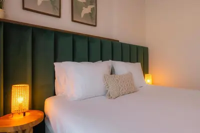 a bedroom with a large bed with a green headboard at Sweet Formosa View in Faro