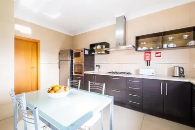 a kitchen with a table with a bowl of fruit on it at Villa Aica - BY BEDZY in Guia