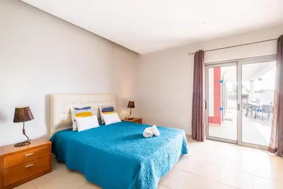 a bedroom with a bed with a blue blanket at Villa Aica - BY BEDZY in Guia