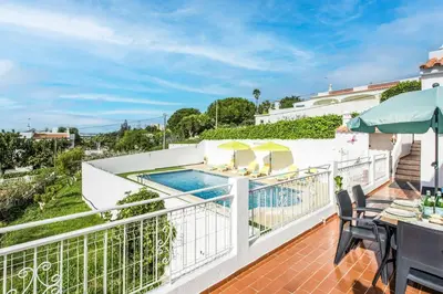 a balcony with a pool and a table and chairs at Casa Miranda in Albufeira
