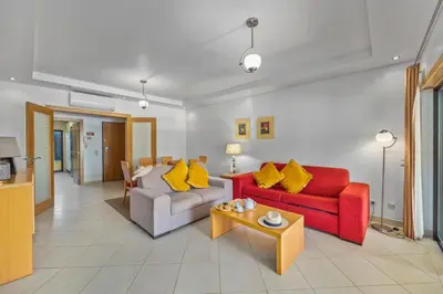 a living room with two couches and a table at Sunny Haven Apartment Vilamoura in Vilamoura