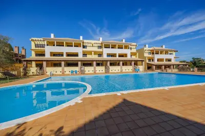a swimming pool in front of a large building at Sunny Haven Apartment Vilamoura in Vilamoura
