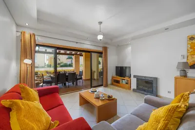 a living room with a red couch and a fireplace at Sunny Haven Apartment Vilamoura in Vilamoura