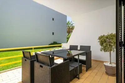 a patio with a table and chairs and a plant at Sal da Viana, Modern Ground Floor, Vilamoura in Vilamoura