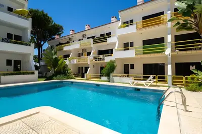 an apartment with a swimming pool in front of a building at Sal da Viana, Modern Ground Floor, Vilamoura in Vilamoura