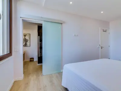 a white bedroom with a bed and a hallway at AL - Vilamoura Top Floor in Vilamoura