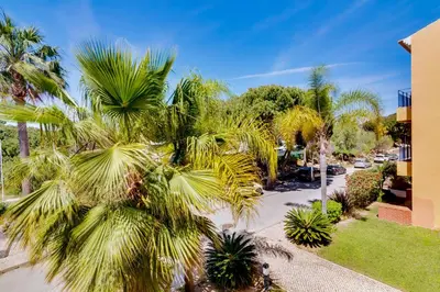 a palm tree in front of a building at AL - Apartamento Vila Sol N in Vilamoura