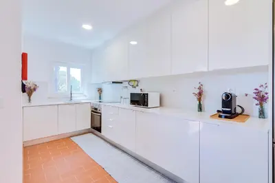 a white kitchen with white counters and appliances at AL - Vila Barreira, near the golf in Vilamoura
