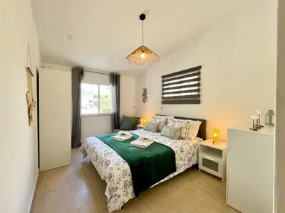a bedroom with a bed with a green and white bedspread at Vilamoura Brightness Villa With Pool by Homing in Vilamoura