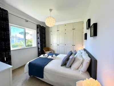 a bedroom with a bed with pillows and a window at Vilamoura Brightness Villa With Pool by Homing in Vilamoura