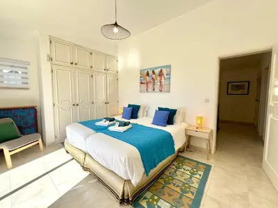 a bedroom with a large bed with blue pillows at Vilamoura Brightness Villa With Pool by Homing in Vilamoura