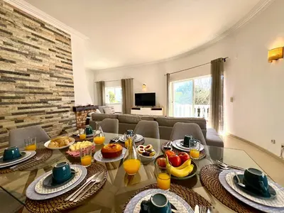 a living room with a table with food on it at Vilamoura Brightness Villa With Pool by Homing in Vilamoura