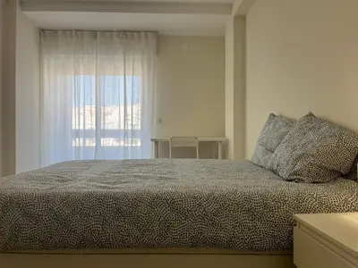 a bedroom with a large bed with a window at Montinho - Apartamento in Faro