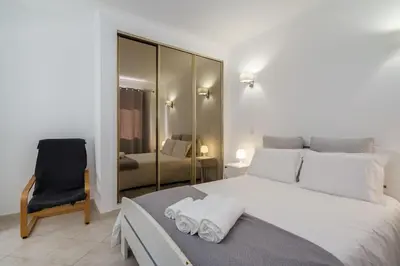 a bedroom with a large white bed and a chair at Villa Verde by IntiHolidays in Guia