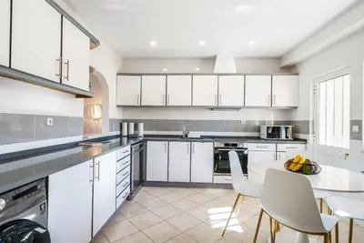 a kitchen with white cabinets and a table and chairs at Villa Verde by IntiHolidays in Guia