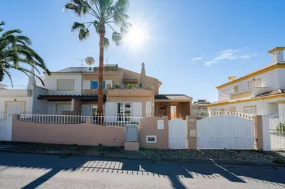a house with a white fence and palm trees at Villa Verde by IntiHolidays in Guia