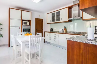 a kitchen with a white table and white chairs at Villa Bonita Gale in Galé