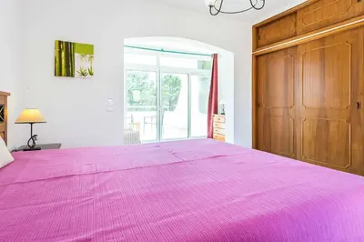 a large purple bed in a room with a window at Villa Bonita Gale in Galé